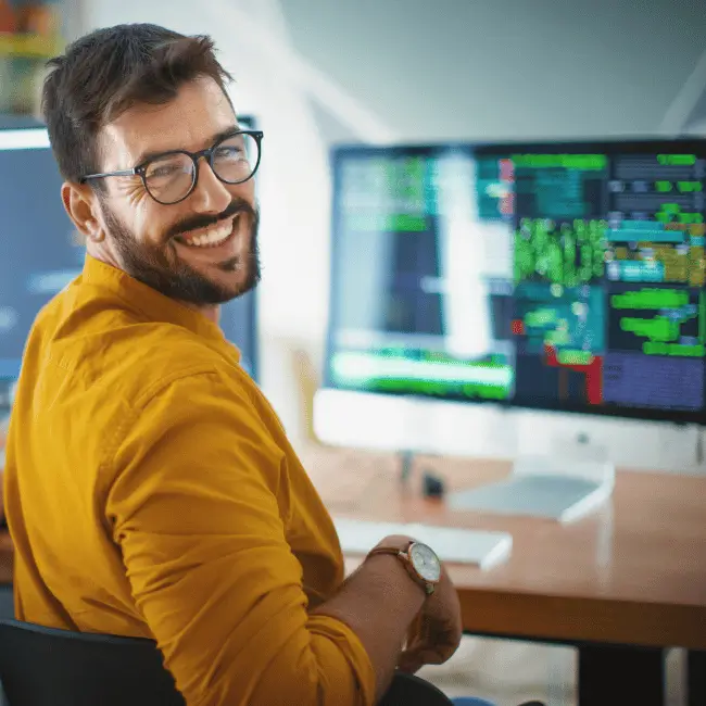 Person working on computer looking towards visitor
